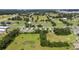 Expansive aerial view of a community with houses, paddocks, and green spaces. Horse facilities and nearby homes at 7054 Sw 64Th Ter, Ocala, FL 34476