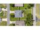 Aerial view of a house with a gray roof, green lawn, surrounded by neighboring homes at 7054 Sw 64Th Ter, Ocala, FL 34476
