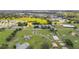 Aerial view of a community with houses, paddocks, green spaces, horse facilities, pond, and nearby city at 7054 Sw 64Th Ter, Ocala, FL 34476