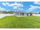 Large backyard features a covered patio, well-kept lawn, and pristine white fencing at 7054 Sw 64Th Ter, Ocala, FL 34476