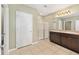 Bright bathroom featuring double sink vanity, white tiled floors and a stand-up glass shower at 7054 Sw 64Th Ter, Ocala, FL 34476