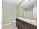 Bathroom featuring double sink vanity, tiled floors, and a shower with tub at 7054 Sw 64Th Ter, Ocala, FL 34476