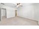 Primary bedroom with neutral carpet, ceiling fan, and an en-suite bathroom at 7054 Sw 64Th Ter, Ocala, FL 34476