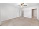 Primary bedroom with neutral carpet, ceiling fan, and closet and bathroom access at 7054 Sw 64Th Ter, Ocala, FL 34476
