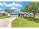 Charming single-story home featuring a well-manicured lawn and an attached two-car garage at 7054 Sw 64Th Ter, Ocala, FL 34476
