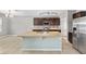Bright kitchen featuring an island, tile backsplash, stainless steel appliances, and track lighting at 7054 Sw 64Th Ter, Ocala, FL 34476