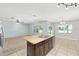 Kitchen with island, stainless dishwasher and sink, tile floors, and view of living and dining area at 7054 Sw 64Th Ter, Ocala, FL 34476