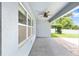Relaxing covered patio features a ceiling fan and views of the beautifully landscaped backyard at 7054 Sw 64Th Ter, Ocala, FL 34476