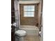 Cozy bathroom features a tiled tub, shower with window and storage shelves at 8134 Fairways Cir # R203, Ocala, FL 34472
