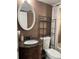 Bathroom with decorative sink, cabinet, oval mirror and shelving over the toilet at 8134 Fairways Cir # R203, Ocala, FL 34472