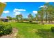 Beautiful backyard featuring lush green lawn and scenic view of the golf course beyond the manicured landscaping at 8380 Sw 82Nd Cir, Ocala, FL 34481