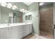 Bright bathroom featuring a double vanity with storage, ample lighting, a large mirror, and glass shower at 8380 Sw 82Nd Cir, Ocala, FL 34481