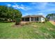 Expansive backyard with manicured lawn, mature trees, and a cozy screened-in lanai at 8640 Sw 83Rd Loop, Ocala, FL 34481