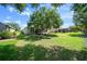 Serene backyard featuring a large, shady tree, lush lawn, and an inviting screened lanai at 8640 Sw 83Rd Loop, Ocala, FL 34481