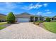 Beautiful single-story home featuring a brick-paved driveway and a well-maintained lawn at 8640 Sw 83Rd Loop, Ocala, FL 34481