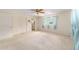 Spacious bedroom with neutral carpet, ceiling fan, and access to the ensuite bathroom at 8704 Sw 94Th Ln # G, Ocala, FL 34481
