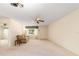 Bright living room featuring a ceiling fan, large window, and neutral carpet creating a cozy space at 8704 Sw 94Th Ln # G, Ocala, FL 34481