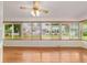 Bright sunroom featuring hardwood floors, neutral walls, and a ceiling fan, all surrounded by many windows at 8704 Sw 94Th Ln # G, Ocala, FL 34481