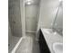 Bathroom with a tiled shower, double vanity with modern fixtures, and neutral color scheme at 8795 Juniper Rd, Ocala, FL 34480