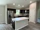 Stylish kitchen featuring dark cabinetry, stainless steel appliances, and a functional center island at 8795 Juniper Rd, Ocala, FL 34480
