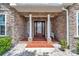 Charming covered front porch with brick accents and decorative white bench, and brick walkway at 9641 Se 70Th Ter, Ocala, FL 34472