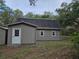 Gambrel-roofed house with white door and trim, offering a serene view of the surrounding trees at 9805 Se 182Nd Avenue Rd, Ocklawaha, FL 32179