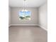 Empty Dining Room with view of neighboring houses through large window at 10008 Sw 85Th Place Rd, Ocala, FL 34481