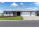Charming one-story home featuring a three-car garage, manicured lawn, and paver driveway under a sunny sky at 10008 Sw 85Th Place Rd, Ocala, FL 34481