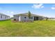 The home has a large backyard, lush green grass, and a screened-in covered patio at 10026 Sw 85Th Place Rd, Ocala, FL 34481