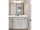 Bathroom vanity featuring white cabinets, bronze hardware, and a large mirror reflecting natural light at 10026 Sw 85Th Place Rd, Ocala, FL 34481