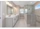 Bathroom boasting double sink vanity, a glass-enclosed walk-in shower, and neutral color scheme at 10026 Sw 85Th Place Rd, Ocala, FL 34481