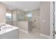 Bathroom showcasing walk-in shower with a glass enclosure, and neutral toned tiling and a white vanity at 10026 Sw 85Th Place Rd, Ocala, FL 34481