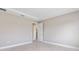 Clean, empty bedroom with neutral walls, a large window, tile flooring, and an open doorway at 10026 Sw 85Th Place Rd, Ocala, FL 34481