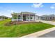 Landscaped single-story home with a three-car garage, patterned brick driveway, and a well-manicured lawn at 10026 Sw 85Th Place Rd, Ocala, FL 34481