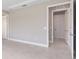 Neutral-toned hallway showcasing open doorways and tile flooring leading to various rooms in the home at 10026 Sw 85Th Place Rd, Ocala, FL 34481