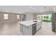 Modern kitchen features a large island with a white countertop, stainless steel appliances, and an open floor plan at 10026 Sw 85Th Place Rd, Ocala, FL 34481