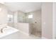 Bathroom with double vanity and large walk-in shower featuring river rock floor and neutral tile at 10045 Sw 82Nd Place Rd, Ocala, FL 34481