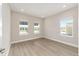 Light-filled bedroom with three windows and wood-look floors at 10045 Sw 82Nd Place Rd, Ocala, FL 34481