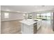 Open-concept kitchen with large island, stainless steel appliances and sliding doors to the backyard at 10045 Sw 82Nd Place Rd, Ocala, FL 34481