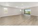 Spacious living room with wood-look floors and sliding glass doors to the outdoor patio at 10045 Sw 82Nd Place Rd, Ocala, FL 34481