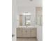 Bright bathroom featuring a large mirror, double sink vanity, and glass-enclosed shower at 10561 Sw 98Th Pl, Ocala, FL 34481
