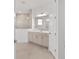 Bright bathroom featuring a large mirror, double sink vanity, and glass-enclosed shower at 10561 Sw 98Th Pl, Ocala, FL 34481