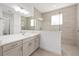 Bathroom featuring a large mirror, double sink vanity, and glass-enclosed shower at 10561 Sw 98Th Pl, Ocala, FL 34481