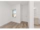 Light-filled bedroom with wood-look flooring, a window, and a door to the bathroom at 10561 Sw 98Th Pl, Ocala, FL 34481