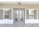 Elegant front door with decorative glass panes flanked by windows with charming shutters at 10561 Sw 98Th Pl, Ocala, FL 34481