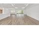 Open-concept living space with wood floors, recessed lighting, and sliding glass doors to the lanai at 10561 Sw 98Th Pl, Ocala, FL 34481
