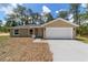 Charming single-story home with a two-car garage, a well-manicured lawn, and a welcoming facade at 1083 Sw Winding Hills Rd, Dunnellon, FL 34431