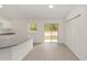 Eat-in kitchen and living space with modern white cabinets, light gray counters, and sliding glass doors at 1083 Sw Winding Hills Rd, Dunnellon, FL 34431