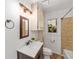 Bathroom with vanity, mirror, tile shower, and window at 11430 Se 54Th Ave, Belleview, FL 34420