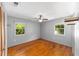 Bright bedroom with two large windows, gray walls, ceiling fan, and hardwood floors at 11430 Se 54Th Ave, Belleview, FL 34420